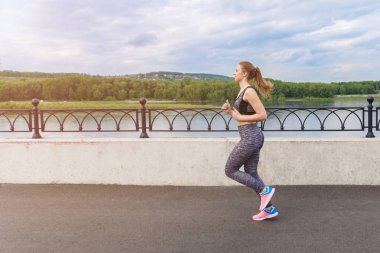 Güneş doğarken şehirde Rıhtımlar üzerinde koşan kız