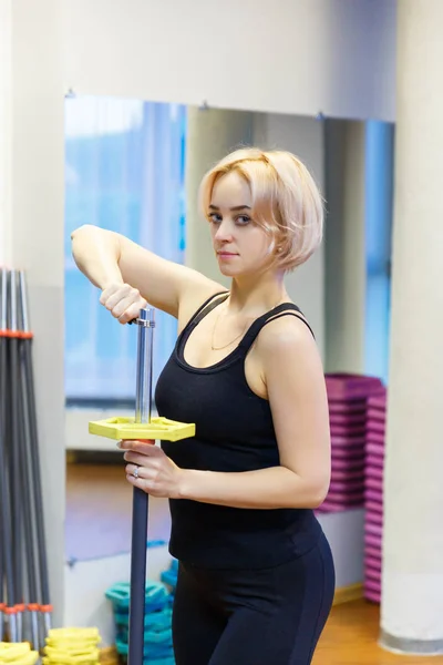 Egy fiatal nő, bár gazdaság, arra készül, hogy vegyenek részt az edzőteremben fitness. Ő úgy néz ki, a kamera, és beállítható, hogy végre sport gyakorlására. — Stock Fotó