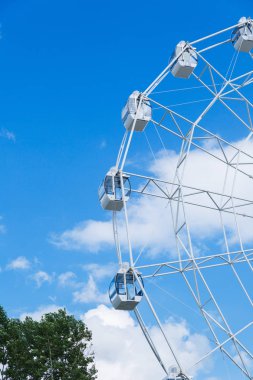 Dönme dolap mavi gökyüzü ve bulutlar karşı. Değil tam tekerlek