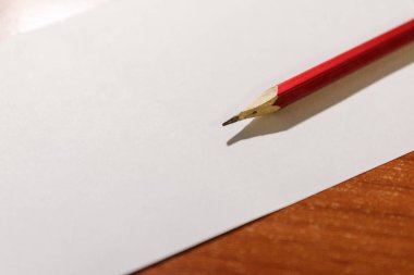 Basit bir kalem beyaz bir kağıt parçası üzerinde yatıyor. Kalem ve kağıt notları.