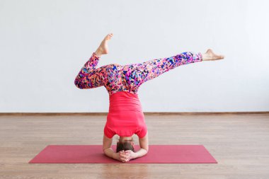 Genç bir kız kafasına dikilirken akrobasi yapar.