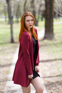 Ağaçların arasında Parkta kızıl saçlı ince kız