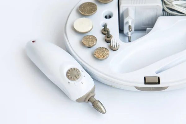 Máquina de manicura eléctrica y un conjunto de accesorios para el tratamiento de uñas . — Foto de Stock