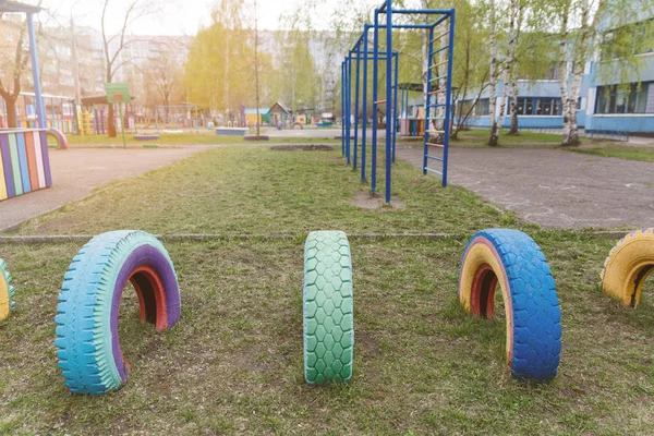 Children's Playground in the kindergarten. Multi-colored wheel games. Old wheels from cars are painted in different colors. — Stock Photo, Image