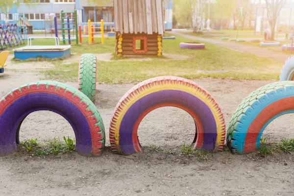 Children's Playground in the kindergarten. Multi-colored wheel games. Old wheels from cars are painted in different colors. — Stock Photo, Image