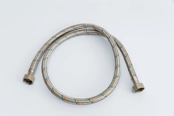 Flexibles Wasserrohr aus Metallgeflecht auf weißem Hintergrund zu einem Ring verdreht — Stockfoto