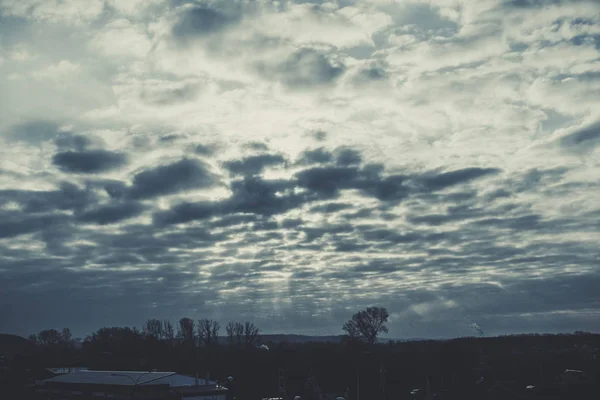 Die Sonnenstrahlen durch die Wolken über dem Wald. dunkle Wolken bei Sonnenaufgang in Sibirien. Sibirische Landschaft. — Stockfoto