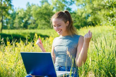 Kız çok şaşırmış ve dizüstü bilgisayar monitörü bakarak mutlu.