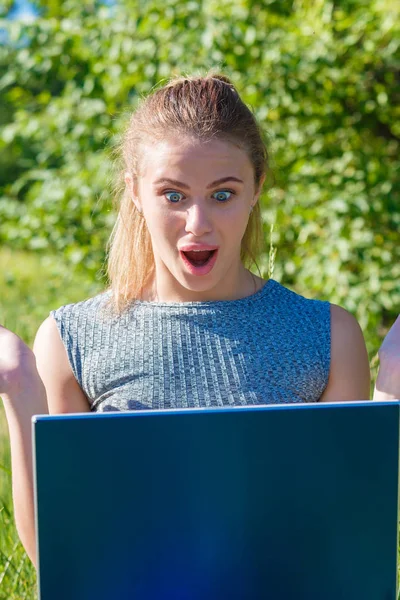 Το κορίτσι είναι πολύ έκπληκτος και χαρούμενος κοιτάζοντας την οθόνη του φορητού υπολογιστή. — Φωτογραφία Αρχείου