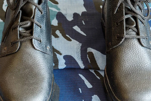 Leger laarzen en leger riem op blauwe camouflage stof. Overall voor de soldaat. — Stockfoto