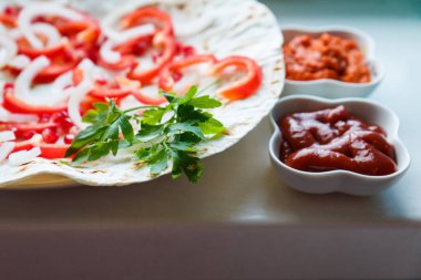Kırmızı biber, nar tohumu, kızarmış pide üzerine maydanoz yaprağı. Lezzetli ızgara et için substrat. Et sosları, ketçap, Ermeni Aivar. Dikey fotoğraf.