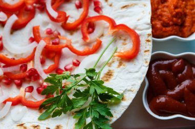 Kırmızı biber, nar tohumu, kızarmış pide üzerine maydanoz yaprağı. Lezzetli ızgara et için substrat. Et sosları, ketçap, Ermeni Aivar. Dikey fotoğraf.