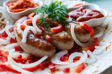 Ketçap lı pide de kızarmış domuz sosisi ve sebzeli Ermeni mezesi Aivar. Lavaş, kırmızı biber, soğan, sosis. Oktoberfest gıda, pub kavramı