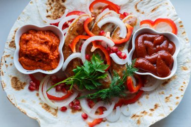 Ketçap lı pide de kızarmış domuz sosisi ve sebzeli Ermeni mezesi Aivar. Lavaş, kırmızı biber, soğan, sosis. Oktoberfest gıda, pub kavramı