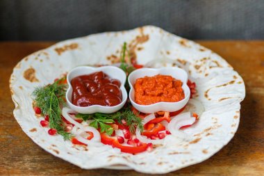 Kırmızı biber, nar tohumu, kızarmış pide üzerine maydanoz yaprağı. Lezzetli ızgara et için substrat. Et sosları, ketçap, Ermeni Aivar. Yatay yakın çekim fotoğraf.