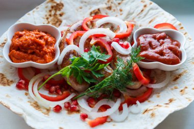 Ketçap lı pide de kızarmış domuz sosisi ve sebzeli Ermeni mezesi Aivar. Lavaş, kırmızı biber, soğan, sosis. Oktoberfest gıda, pub kavramı