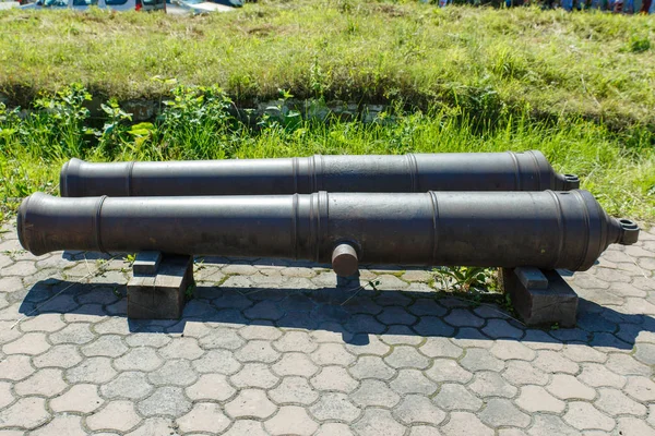 Old guns on wheels in 1812. Artillery fortress guns on wheels. The barrels of artillery guns.