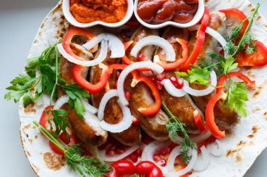 Ketçap lı pide de kızarmış domuz sosisi ve sebzeli Ermeni mezesi Aivar. Lavaş, kırmızı biber, soğan, sosis. Oktoberfest gıda, pub kavramı