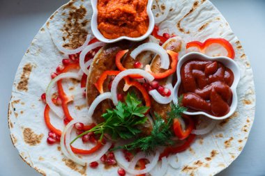 Ketçap lı pide de kızarmış domuz sosisi ve sebzeli Ermeni mezesi Aivar. Lavaş, kırmızı biber, soğan, sosis. Oktoberfest gıda, pub kavramı