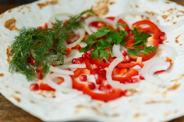 Kırmızı biber, soğan, nar ve maydanoz lavaş üzerine kavrulmuş et, sosis veya sosis ketçap ve Ermeni çerez Aivar ile servis edilir. Yukarıdan görünüm.