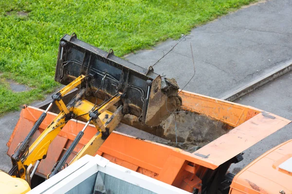 Loading construction debris into the truck for removal to the landfill.