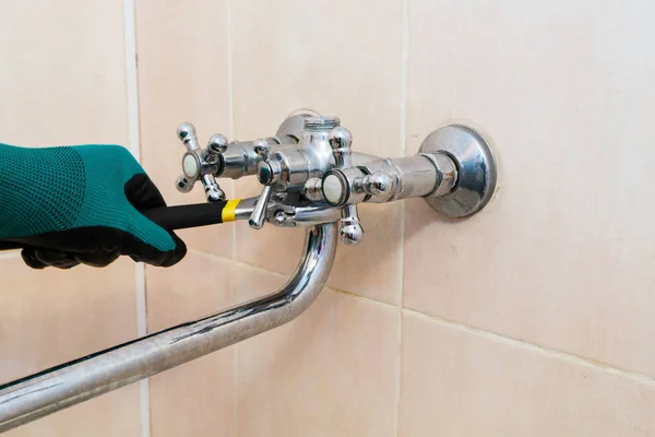 Ένα γάντι με ένα κλειδί επιδιορθώνει τη βρύση στο μπάνιο. — Φωτογραφία Αρχείου