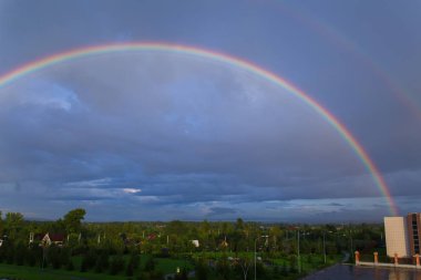 Yağmurdan sonra mavi bulutların arka planında gökyüzünde çift gökkuşağı.