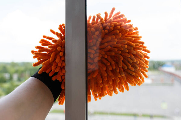 Part of the hand with a window cleaning mitt.