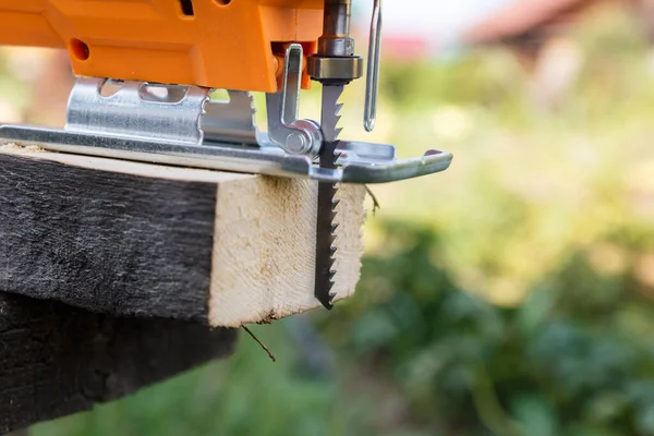 Tahta üzerinde yeni kesilmiş bir testereyle elektrikli bir yapboz var..