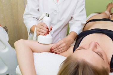 Genç bir kadının ellerinde anti-selülit masajı. Mağara.