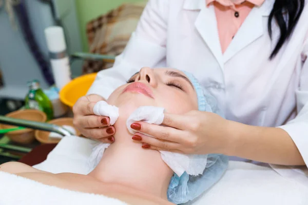 Young woman in spa salon on facial skin care procedures. Facial skin rejuvenation and cleansing in a beauty salon.