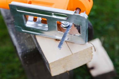 Elektrikli yapboz ve ahşap tahta. Taze kesilmiş ve talaşlı..