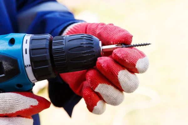 Bir Marangozun Elindeki Pilin Üzerindeki Elektrikli Tornavida Eldivenli Erkek Eller — Stok fotoğraf