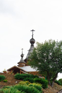 Bulutsuz, aydınlık gökyüzüne karşı koni şeklinde çatısı olan güzel, ahşap bir tapınak. Dikey fotoğraf