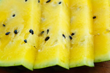 İçinde sarı posa ve siyah tohumlar olan birkaç dilim karpuz..