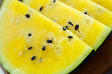İçinde sarı posa ve siyah tohumlar olan birkaç dilim karpuz..