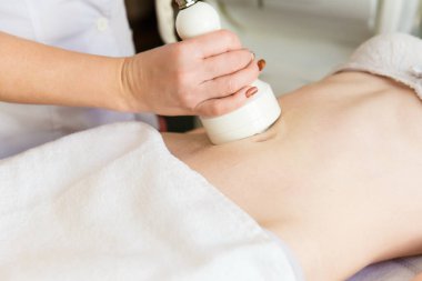 Kaviteli vücut masajı. Masaj masasındaki genç kız selülit masajı karşıtı.