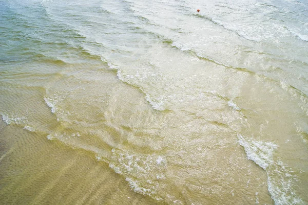 Superior-vista-de-pequeno-ondas-de-um-mar-surf-em-rasa-água-com-areia — Fotografia de Stock