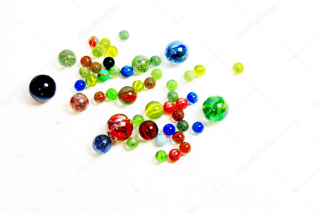 Top view of various multicolored glass balls on white background