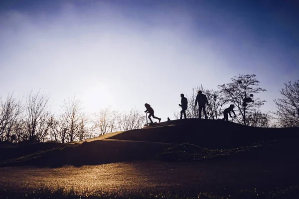 Silhouette di bambini nello skate park al tramonto — Foto Stock