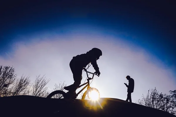 Silhouetten van kinderen in de skate-park bij zonsondergang — Stockfoto