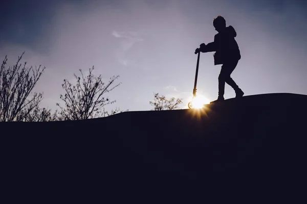 Siluetter av barn i skatepark vid solnedgången — Stockfoto