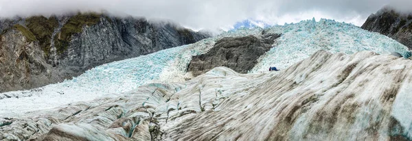 Franz Josef glacier, South Island Yeni Zelanda, kimliği belirsiz yürüyüşçü ile panoramik manzaralı
