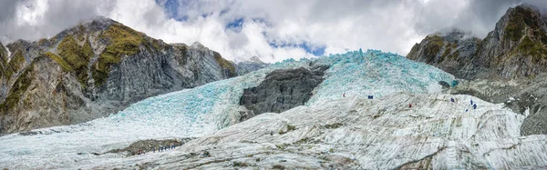 Franz Josef glacier, South Island Yeni Zelanda, kimliği belirsiz yürüyüşçü ile panoramik manzaralı