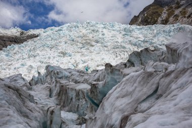 Franz Josef Glacier, zirvesine gölge ön plan buz üzerinde uçan helikopter; South Island Yeni Zelanda