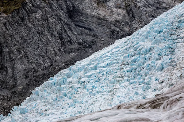 蓝色冰与黑色灰色岩石并列在 Franz 约瑟夫冰川 南海岛新西兰 — 图库照片