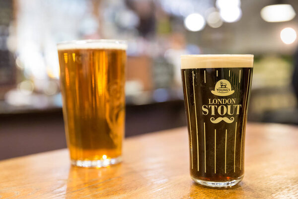 London UK 10 июня 2015: Пинта лондонского Stout в пабе на рынке Leadenhall в Lime Street Passage, Лондон, Великобритания
