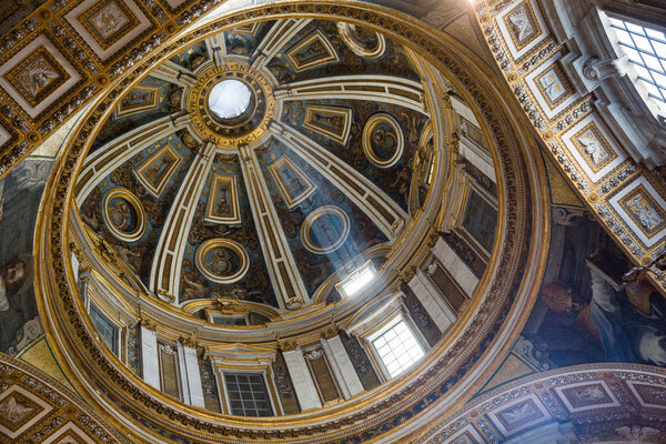 Rome Italy June 27 2015 : A shaft of light illuminates beautiful details of a dome inside St Peter's Basilica in Rome