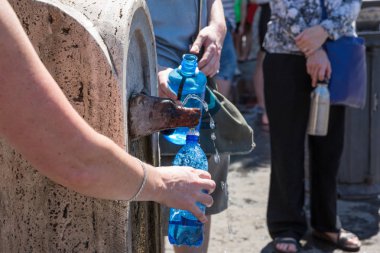 Roma İtalya 29th Haziran 2015: Dolgu içki şişeleri bir kurt baş su Fountain Roma, İtalya
