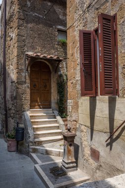 Pitigliano İtalya 30th Haziran 2015: Bir su Çeşme evleri arasında dar geçitler ile Pitigliano, Toskana bölgesindeki kepenkli pencere eşiği